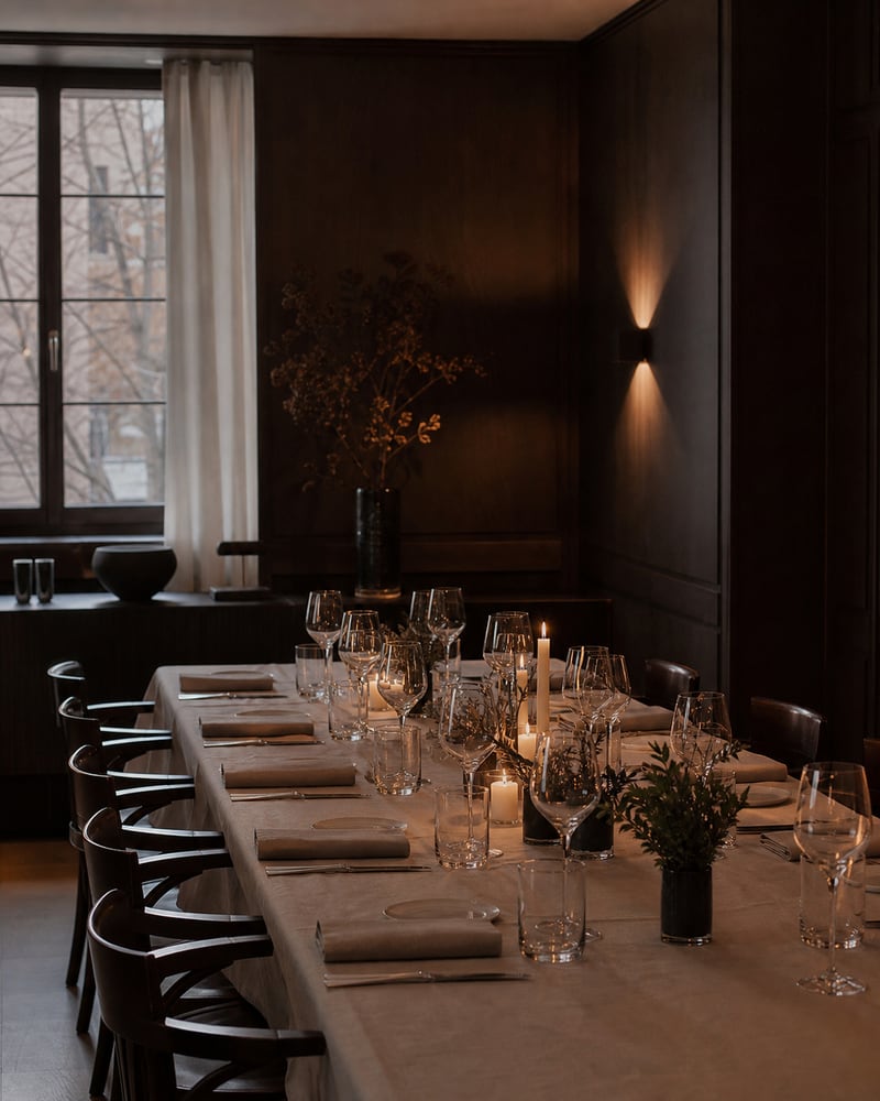 Privater Speisesaal mit dunklem Holz, langer gedeckter Tafel und Kerzenlicht