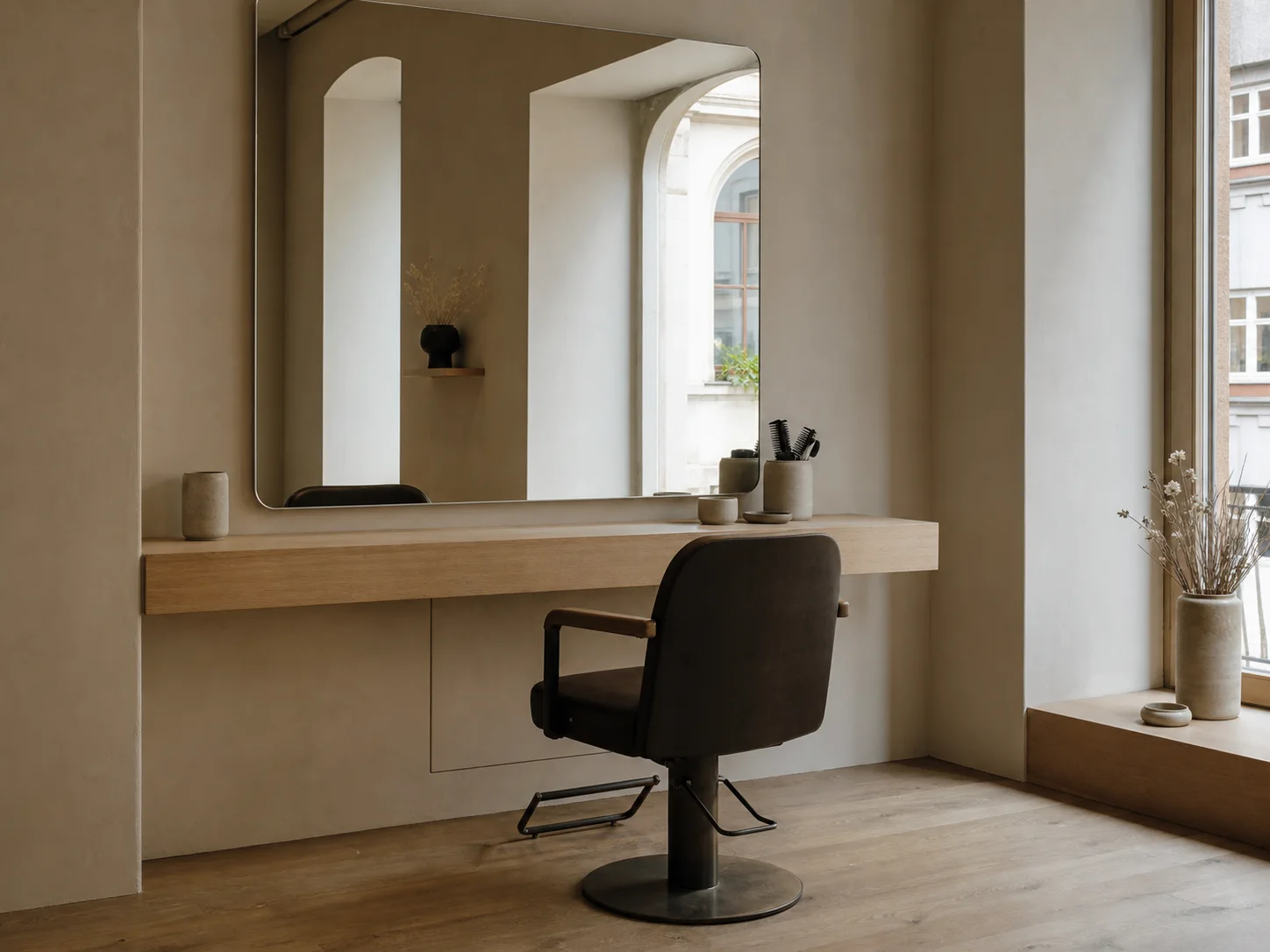 Coiffeur-Station mit grossem Spiegel, warmem Holzdetail und ruhiger Beleuchtung.